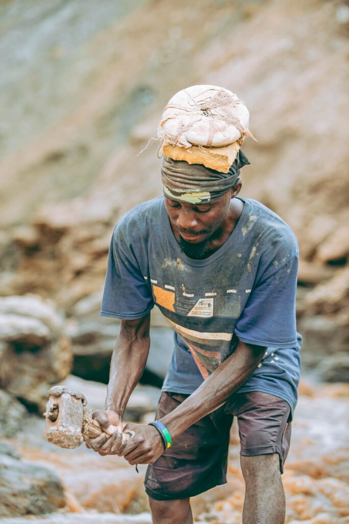 A man engaged in outdoor labor using traditional tools in a rural setting, conveying hard work.